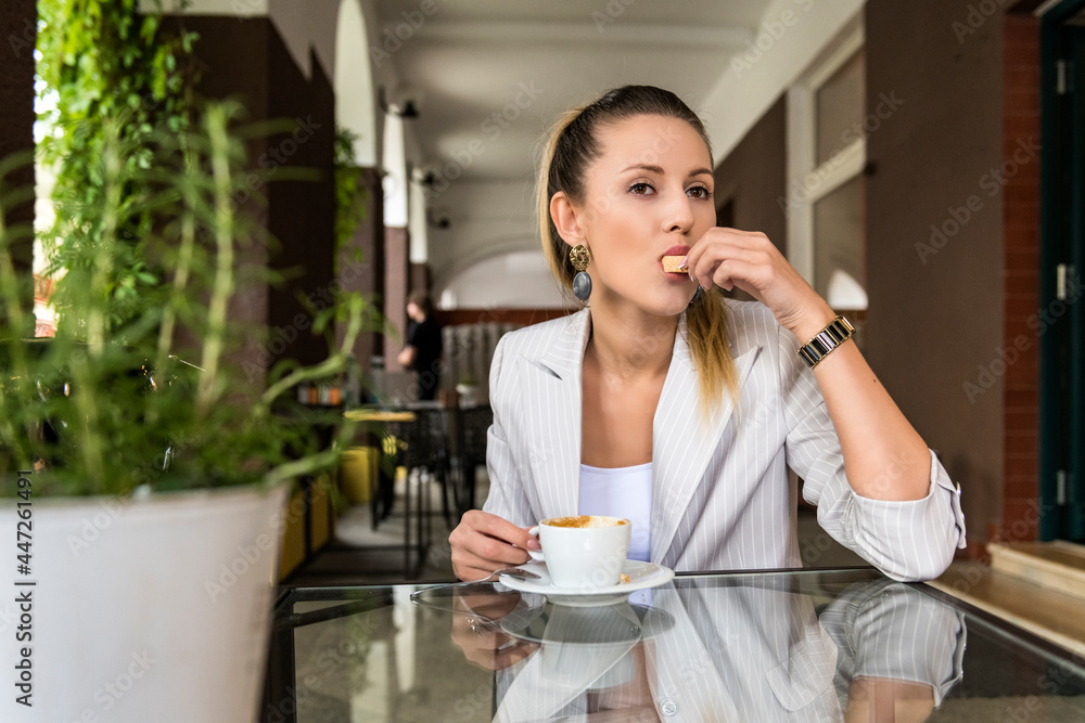 young beautiful elegant woman is drinking a drink on the terrace in the cafe young beautiful elegant woman is drinking a drink on the terrace in the cafe