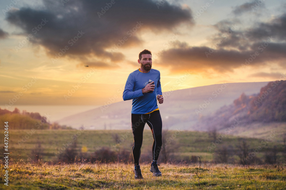 man running in autumn field at sunset man running in autumn field at sunset