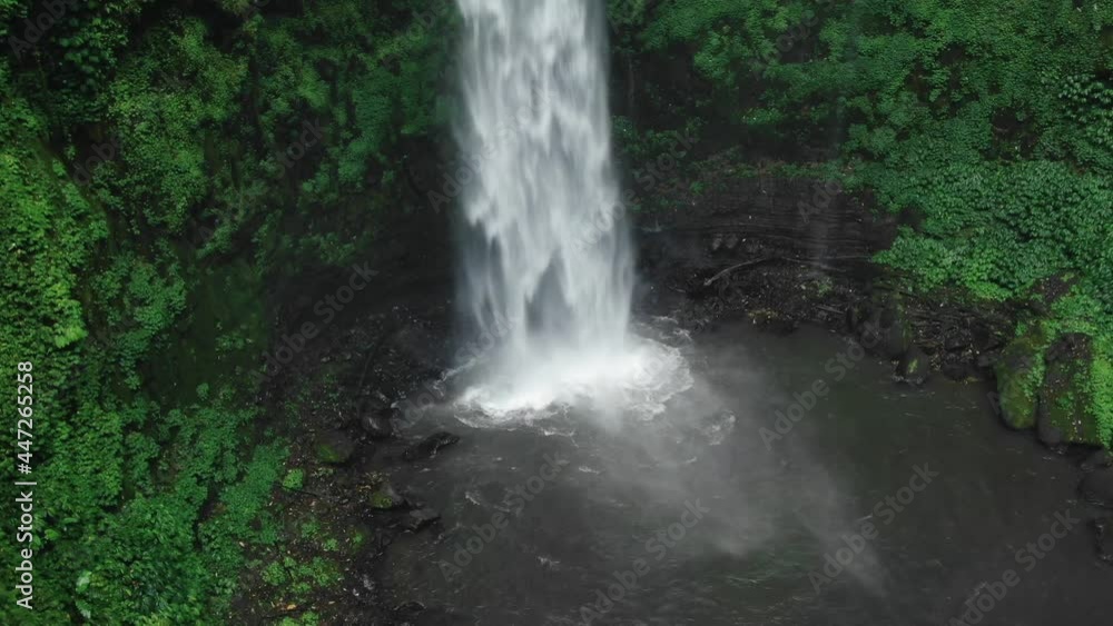 Waterfall in green rainforest. Aerial view of NungNung waterfall in the mountain jungle. Aerial footage. Bali, Indonesia. Travel concept. Waterfall in green rainforest. Aerial view of NungNung waterfall in the mountain jungle. Aerial footage. Bali, Indonesia. Travel concept.