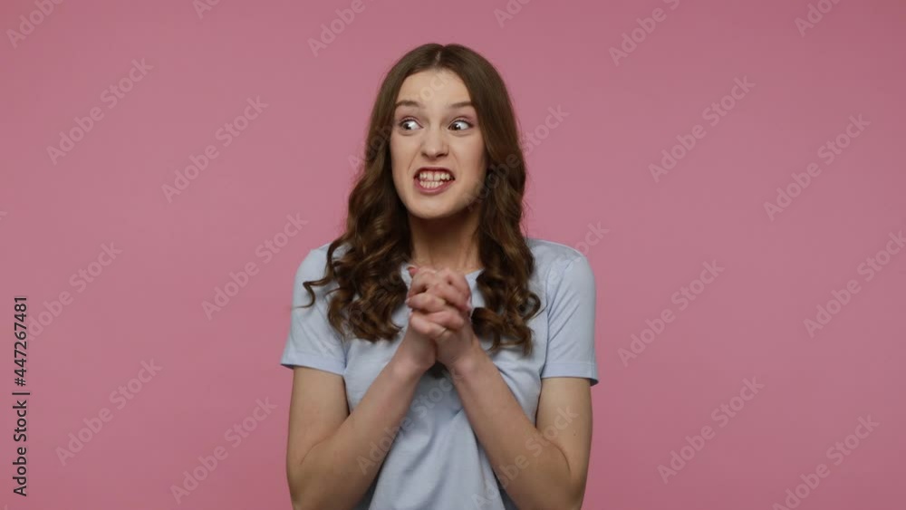 Euphoric thrilled teenager girl with brown wavy hair in T-shirt sincerely laughing and rejoicing, celebrating her lottery victory, success. Indoor studio shot isolated over pink background. Euphoric thrilled teenager girl with brown wavy hair in T-shirt sincerely laughing and rejoicing, celebrating her lottery victory, success. Indoor studio shot isolated over pink background.