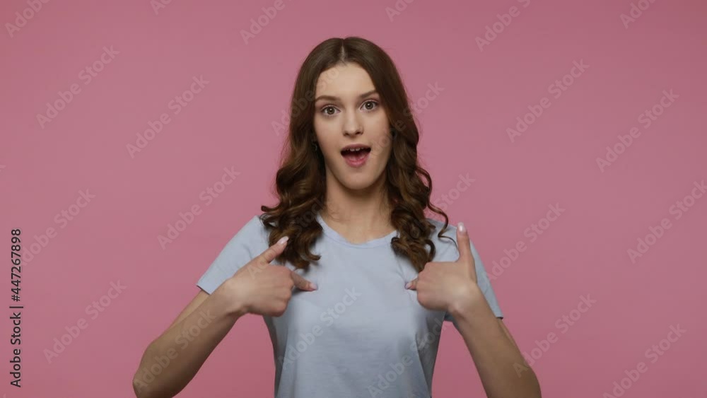 This is me! Happy excited young female in T-shirt pointing herself, looking around and bragging everyone about own success, proud of achievement. Indoor studio shot isolated over pink background. This is me! Happy excited young female in T-shirt pointing herself, looking around and bragging everyone about own success, proud of achievement. Indoor studio shot isolated over pink background.