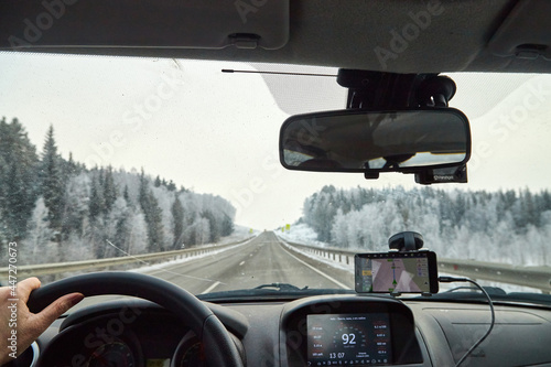Siberia, Russia - November 28, 2020: View from of car interior from side of driver to the road and nature landscape through the windshield © keleny
