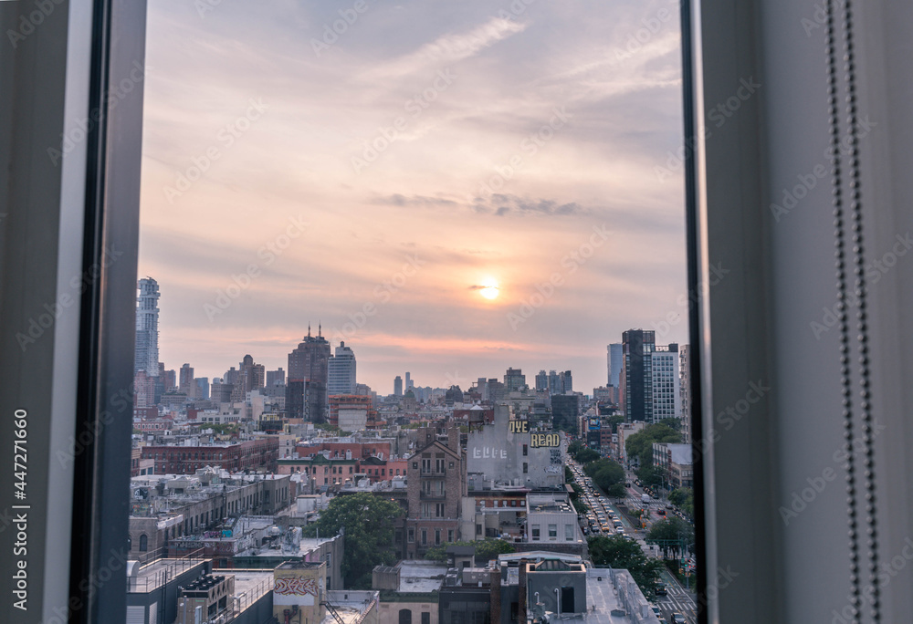 Downtown Manhattan setting sun watched thru a window.