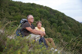 Senior tourist couple sitting on the mountain. Senior couple walking in nature.  travel tourism concept. Outdoor activities on weekends.