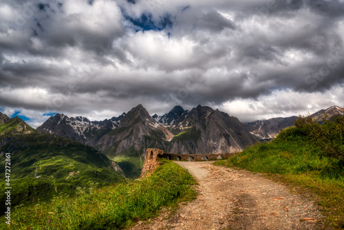 path in the mountains with storm clouds in the sky