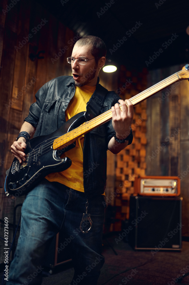 Obraz premium Brutal musician with electric guitar on stage