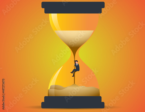 Businessman climbing up sand in hourglass. Concept losing time