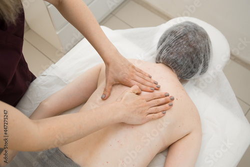 the masseur massages the client's back