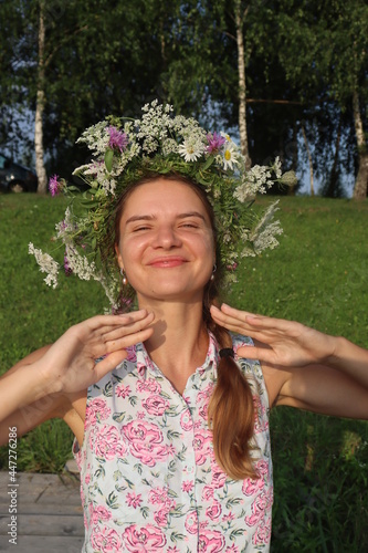 girl with a wicker wreath on her head laughing outdoors spring