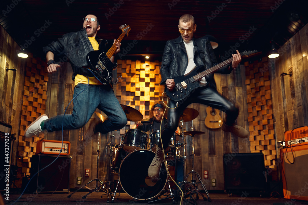 Two brutal musicians jumps with electric guitars