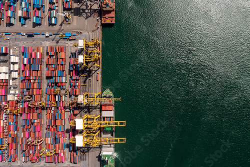Container ship loading and unloading in deep sea port, Aerial top view