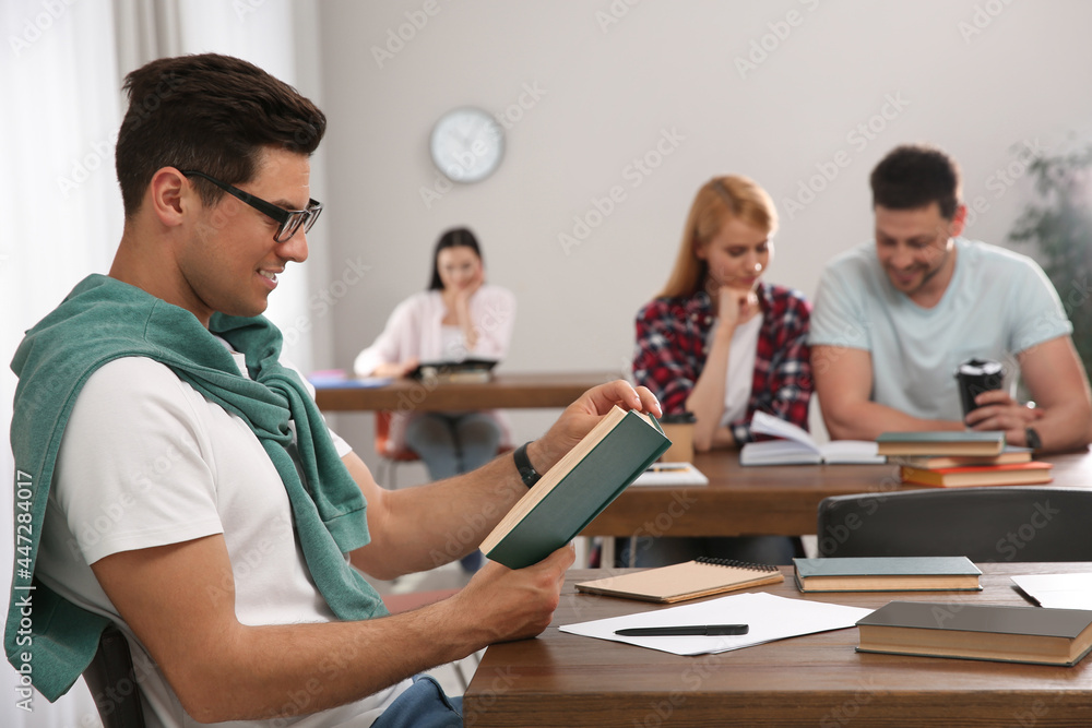 Man reading book at table in library Man reading book at table in library