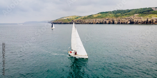 Sail boat sailing along the Jurassic Coast in Devon, South West England  photo