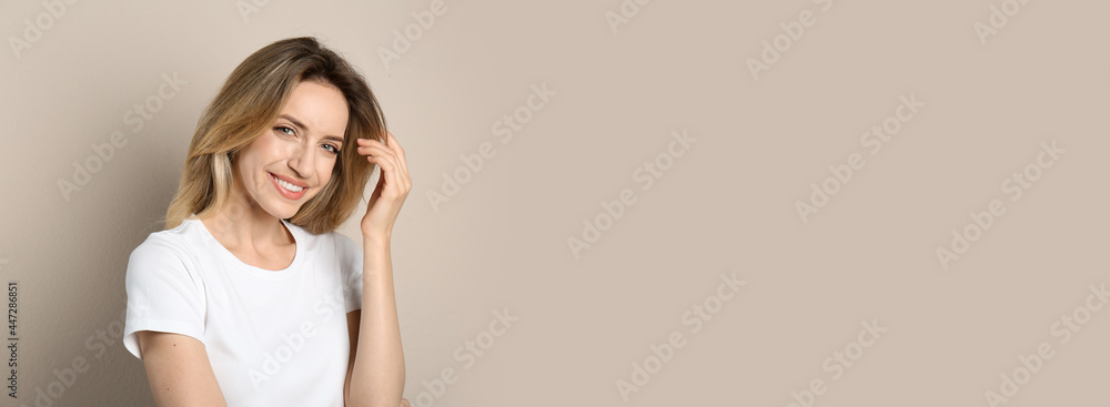 Portrait of happy young woman with beautiful blonde hair and charming smile on beige background Portrait of happy young woman with beautiful blonde hair and charming smile on beige background