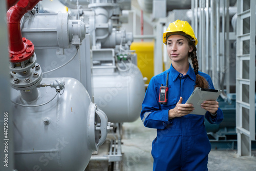 attractive young engineer woman and working engineering in industry.Portrait of young female worker in the factory.Work at the Heavy Industry Manufacturing Facility concept.