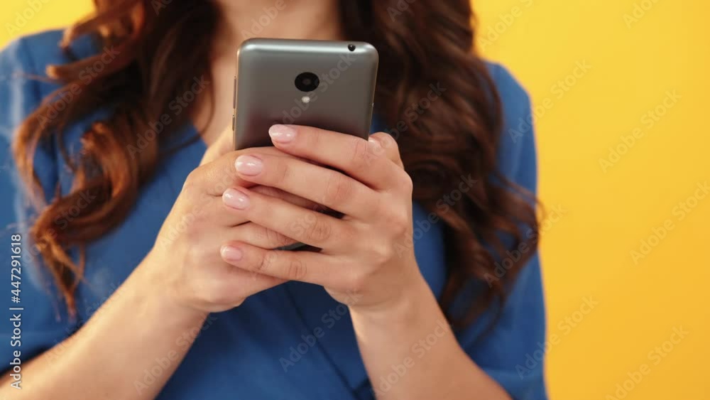 Gadget people. Digital marketing. Mobile technology. Online search. Unrecognizable woman hands using smartphone isolated on blur bright orange background. Gadget people. Digital marketing. Mobile technology. Online search. Unrecognizable woman hands using smartphone isolated on blur bright orange background.
