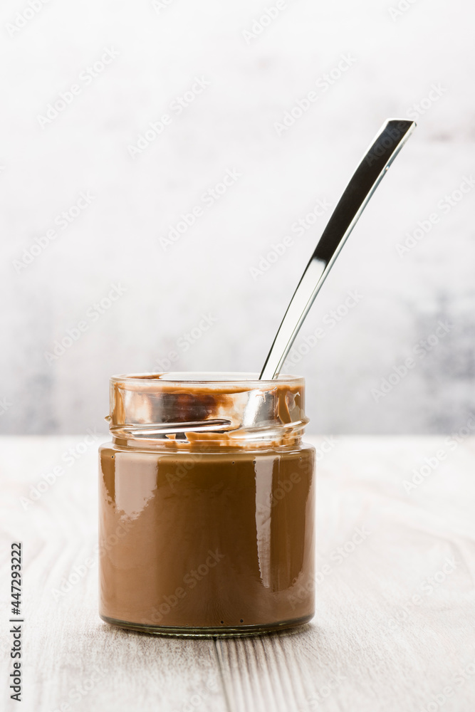 Chocolate cream in glass jar on wooden table Chocolate cream in glass jar on wooden table