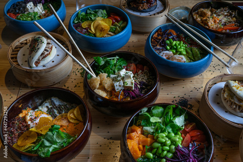 bowls of poke in colorful bowls on a wooden background