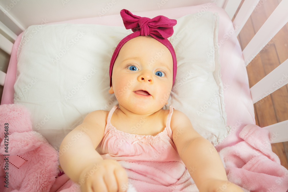 View from above of a little baby girl in pink bed View from above of a little baby girl in pink bed