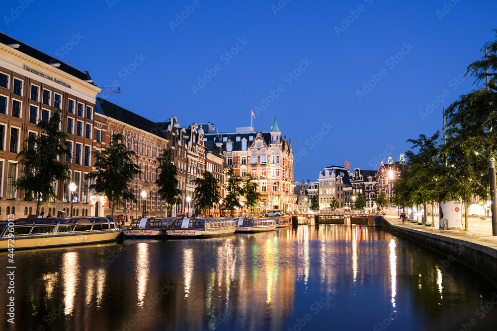 Sunset in the City of Amsterdam with colorfull reflections on the water, Amsterdam, Netherlands, Europe