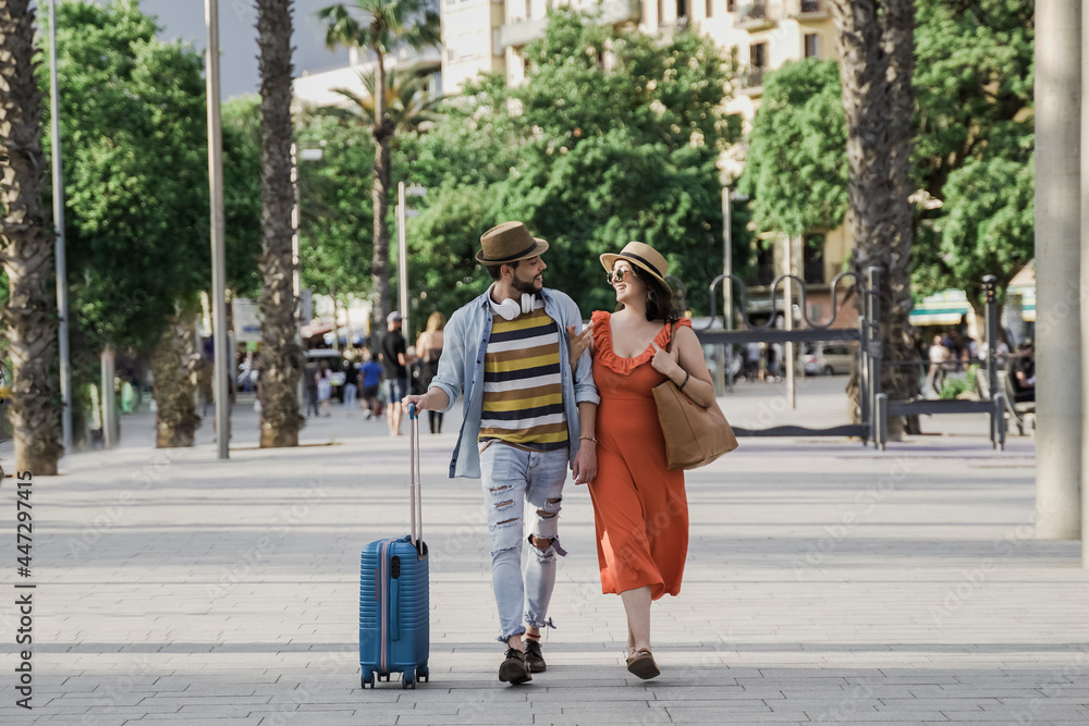 Happy hipster couple of tourist walking by the city at vacation holiday - Tourism and traveler people concept - obrazy, fototapety, plakaty 