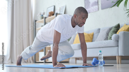 African Man doing Exercise on Yoga Mat at Home