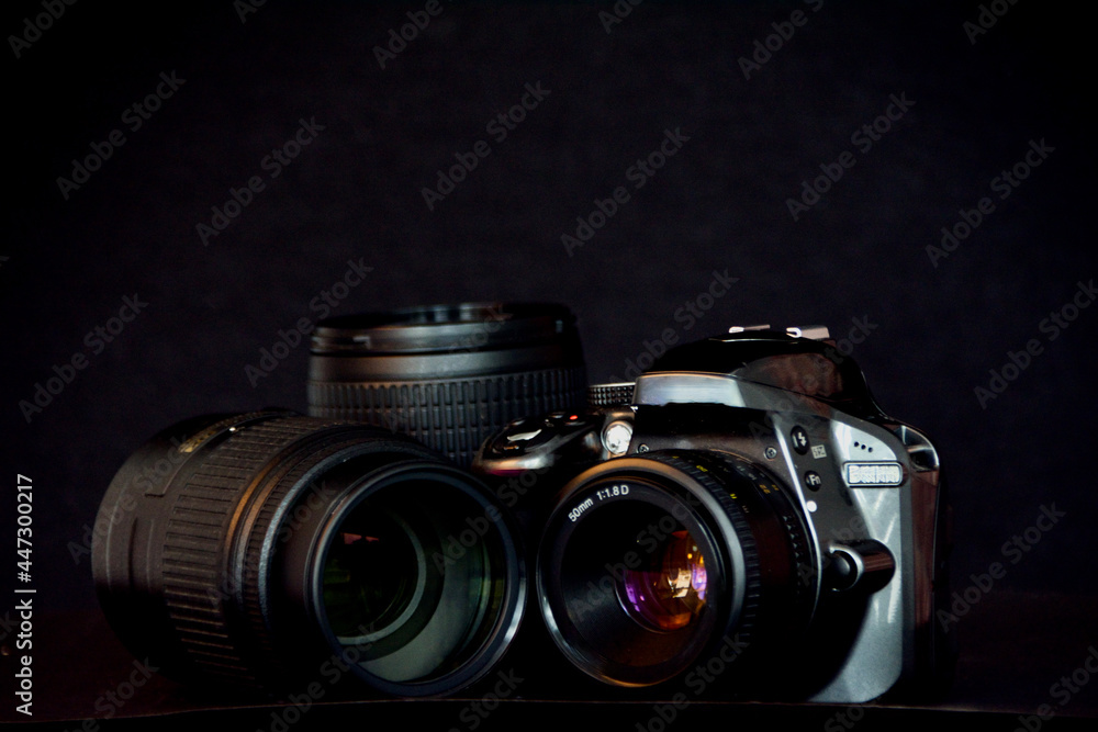 SLR camera and and telephoto lenses on black background
