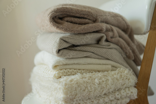 Pile of knitted sweaters. Warm background, knitwear, space for text. Autumn winter concept. Background with sweaters © Анастасія Стягайло