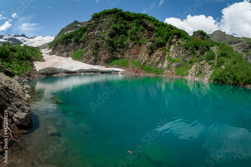 Fotografie mountain lake Turie with the remains of an snow avalanche in Dombai