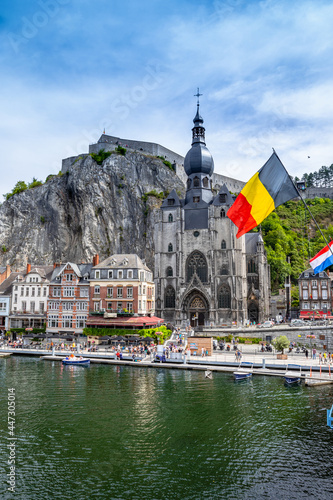 The historic town of Dinant with the Belgian flag and the citadelle on the rock and Collegiate Church of Notre-Dame at the Meuse river, Wallonia, Belgium photo