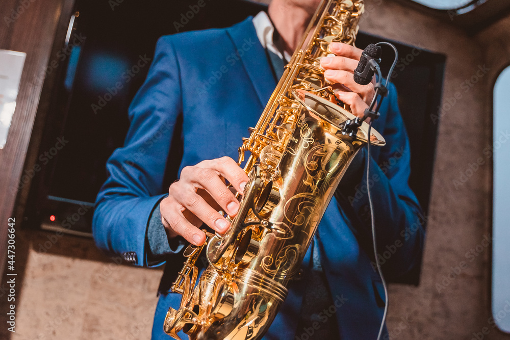 Obraz premium a man plays a saxophone with a microphone attached in front