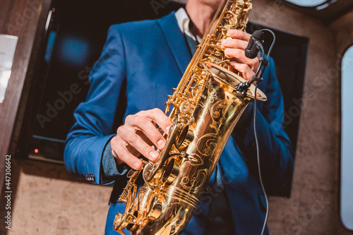 a man plays a saxophone with a microphone attached in front