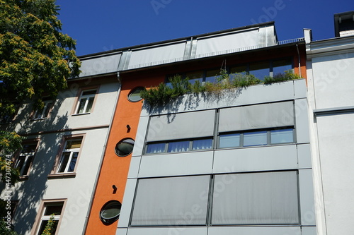 Modernes Wohnhaus mit hellgrauem Sonnenschutz im Sommer bei blauem Himmel und Sonnenschein im Nordend von Frankfurt am Main in Hessen photo