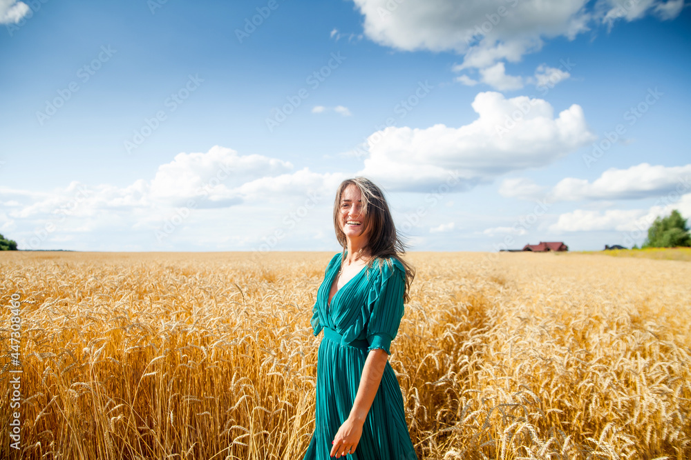 Naklejka premium Girl in dress walking through field of wheat
