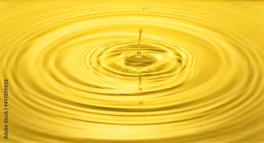 falling drops on the water surface, splash, ripples on the water, yellow color falling drops on the water surface, splash, ripples on the water, yellow color