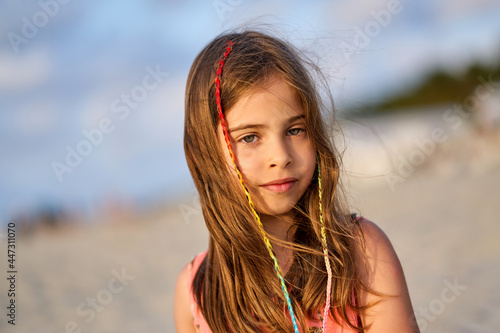 Portrait of a happy little girl on the beach during sunset