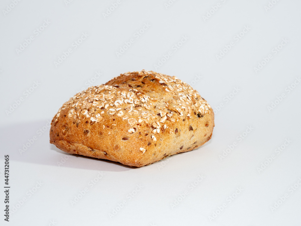 Baked bun soaked in sesame seeds and oatmeal isolated on white background. Baked bun soaked in sesame seeds and oatmeal isolated on white background.