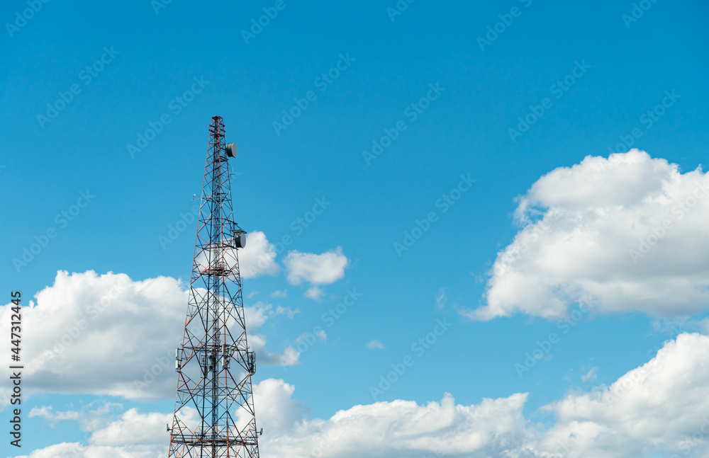 Mobile phone communication radio antenna, 3G, 4G, 5G, 6G. Antenna over cloudy blue sky at summer. Cellular GSM tower with transmitter. Telecommunication base station network. Mobile phone communication radio antenna, 3G, 4G, 5G, 6G. Antenna over cloudy blue sky at summer. Cellular GSM tower with transmitter. Telecommunication base station network.