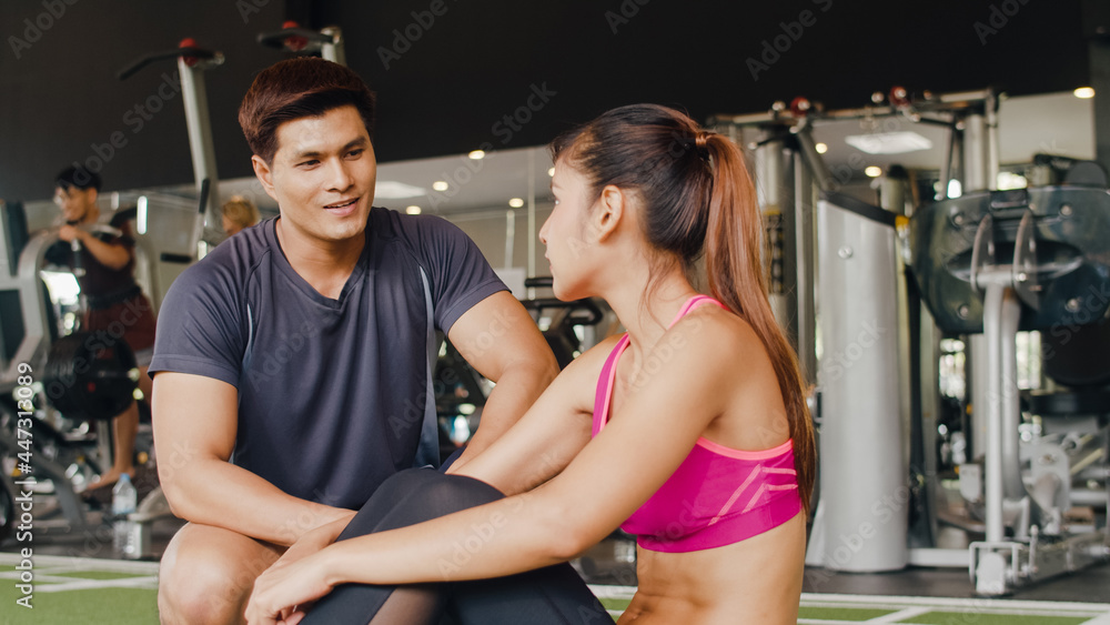 Handsome asian guy personal trainer focus body weight training to lady customer, People training in a gym, Personal trainer in a fitness class, Fitness in gym, sport and healthy lifestyle concept.
