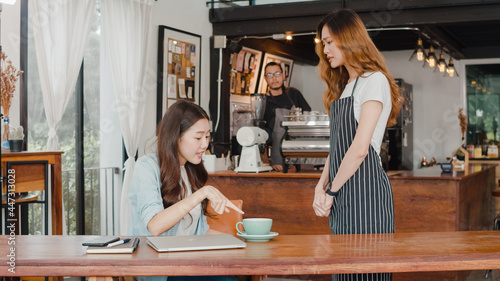 Young Asia freelance lady client talk dispute with millennial waitress feel dissatisfied with cafe bad service, mad disappointed customers speak with staff complain about wrong order coffee shop.