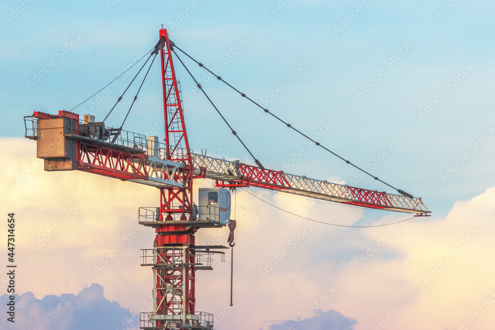 Construction crane on the background of beautiful sunset clouds