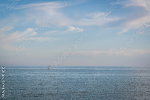 Person doing stand up paddle boarding, Brighton, East Sussex, England, UK