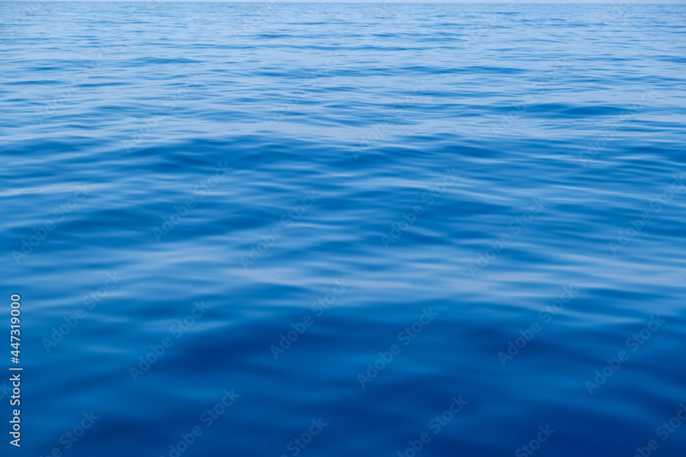 Naklejka premium Sea water surface calm with small ripples. Still ocean, deep blue color background,.