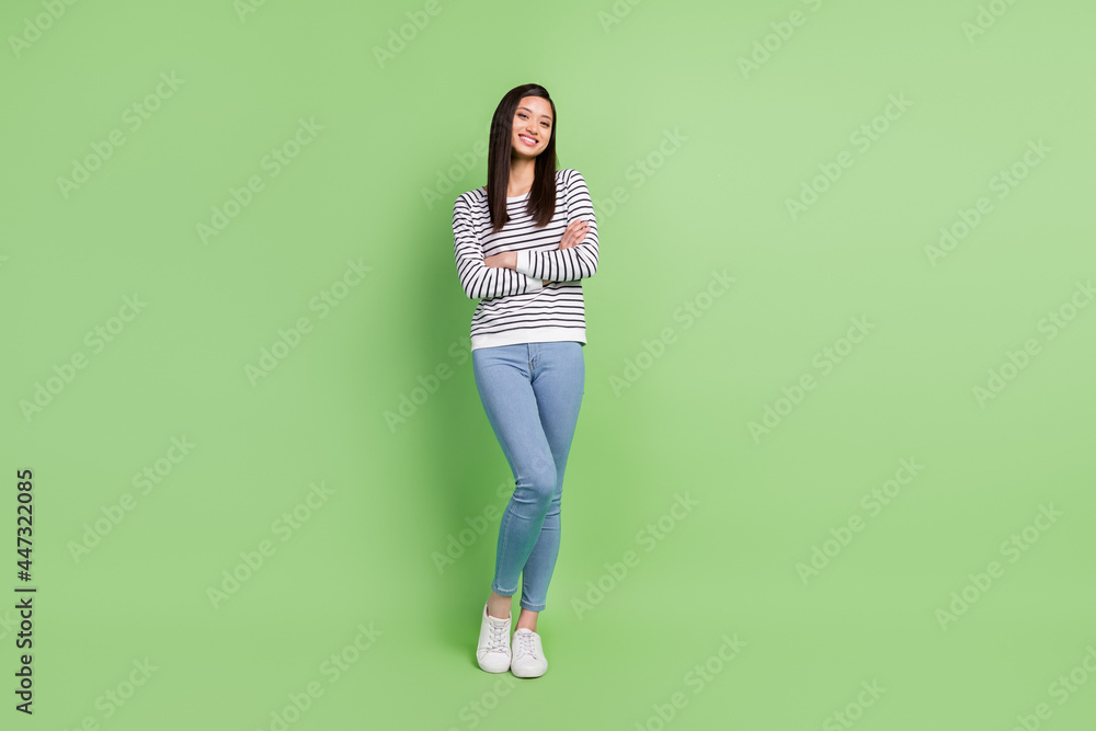 Full length body size view of attractive cheerful slim thin girl posing folded arms isolated over green color background Full length body size view of attractive cheerful slim thin girl posing folded arms isolated over green color background