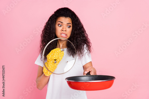 Photo of scared unhappy dark skin lady wear white t-shirt glove looking burned dinner isolated pink color background photo