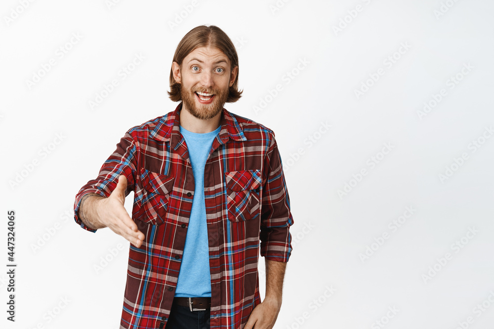 Nice to meet you. Smiling friendly blond man extending his hand for handshake, shaking hands with you, greeting someone, say hello, standing over white background Nice to meet you. Smiling friendly blond man extending his hand for handshake, shaking hands with you, greeting someone, say hello, standing over white background