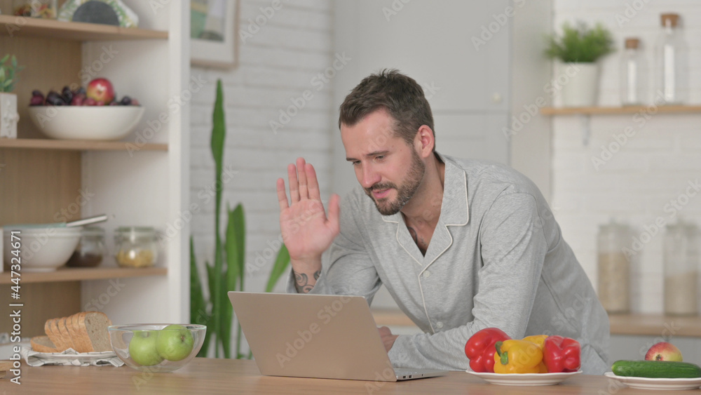 Fototapeta premium Man doing Video Call on Laptop in Kitchen
