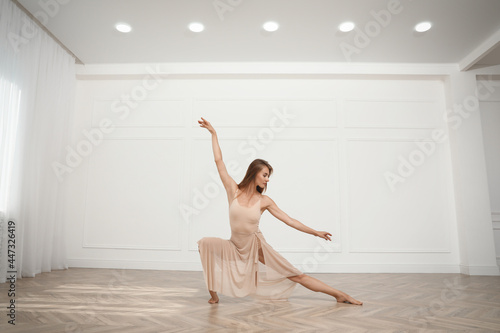 Beautiful professional dancer practicing moves in studio