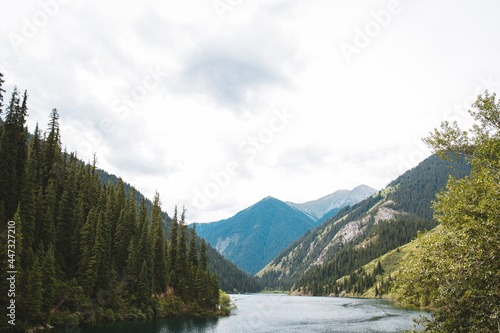 a blue lake among mountains and trees on a summer day.