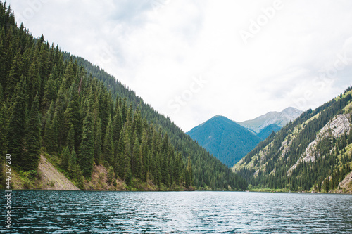 a blue lake among mountains and trees on a summer day